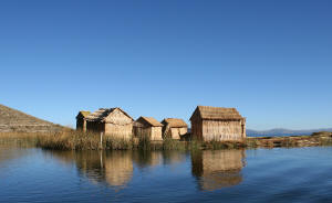 Photo of huts with reflections in a blue pond