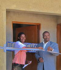 Kgosi Sechele III and Shale cutting ribbon at her new house