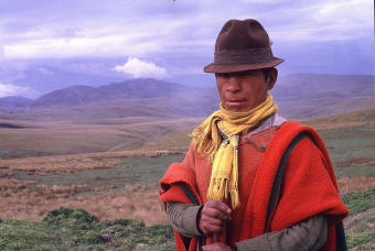Man with hat pulled low, mountains behind
