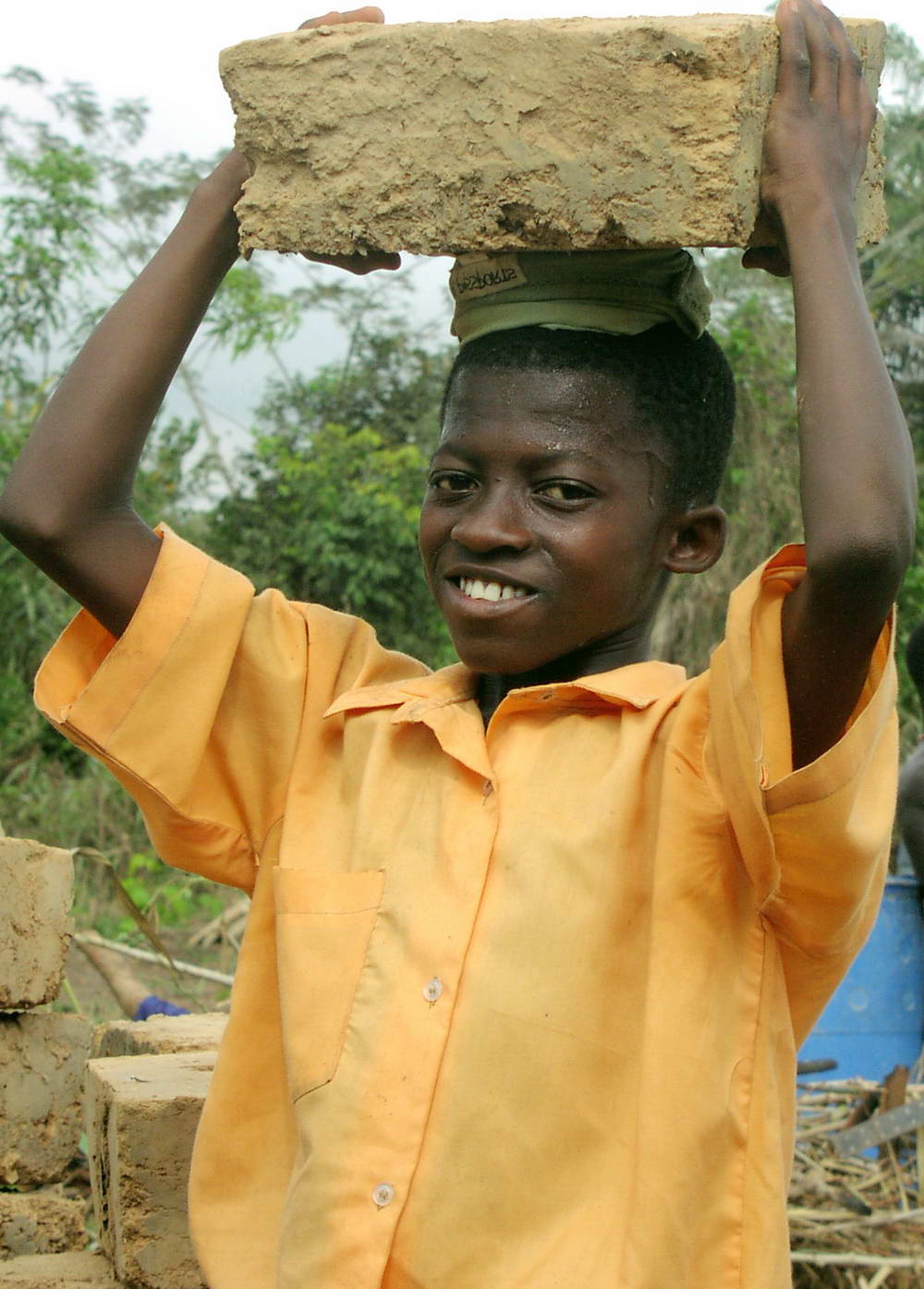 Smiling boy carrying block on his head