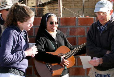 Two volunteers sing along with nun playing guitar