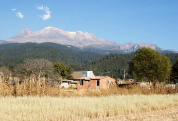 Habitat house behind field in front of volcano