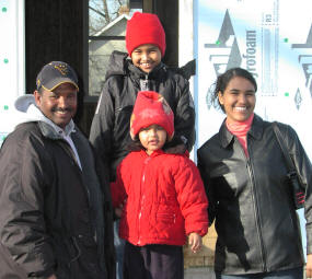 Mother, father, and two children in front of house under construction